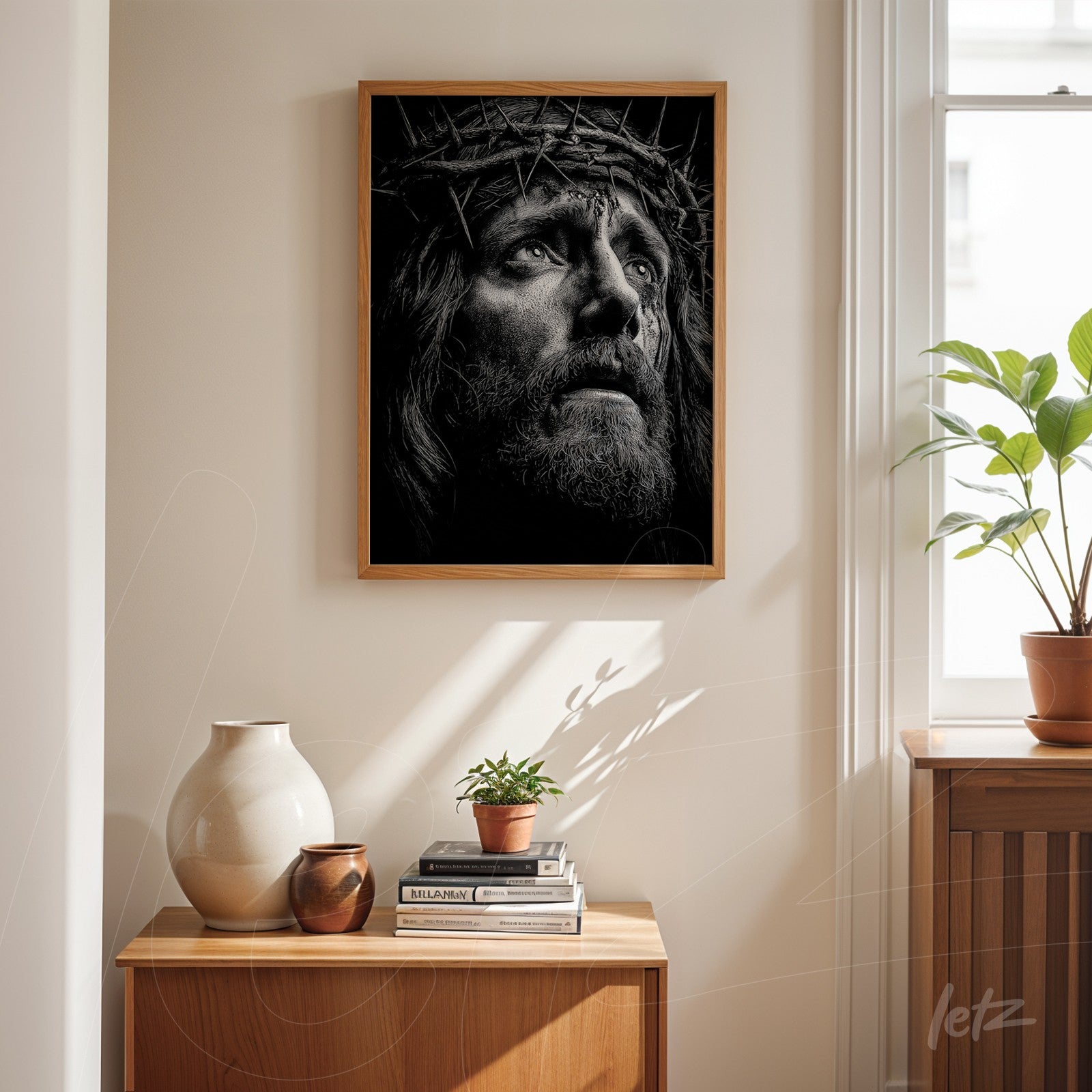 framed wall art in light wood featuring a black and white portrait of Christ with a crown of thorns displayed on a wooden table in a bright room