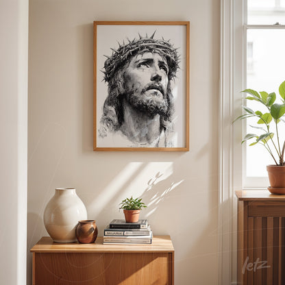 framed wall art featuring a black and white portrait of Christ with a crown of thorns displayed on a light wall