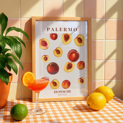 framed art featuring peach illustrations with a light wood frame displayed in a bright setting alongside fruits and plants