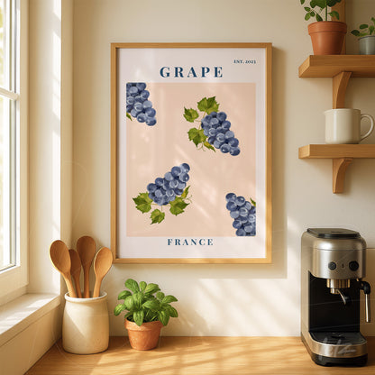 framed art piece with purple grapes on a light pink background displayed in a kitchen setting with wooden shelf