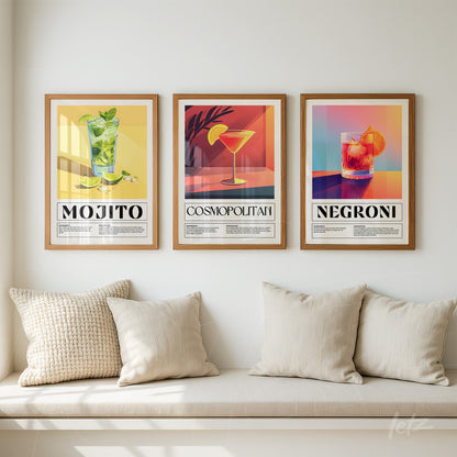 collection of framed wall art featuring classic cocktails mojito, cosmopolitan, and negroni with light wood frames on a soft-colored wall