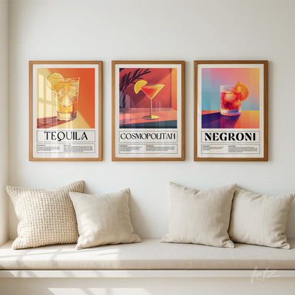 set of framed artworks featuring colorful illustrations of Tequila, Cosmopolitan, and Negroni cocktails with light wood frames