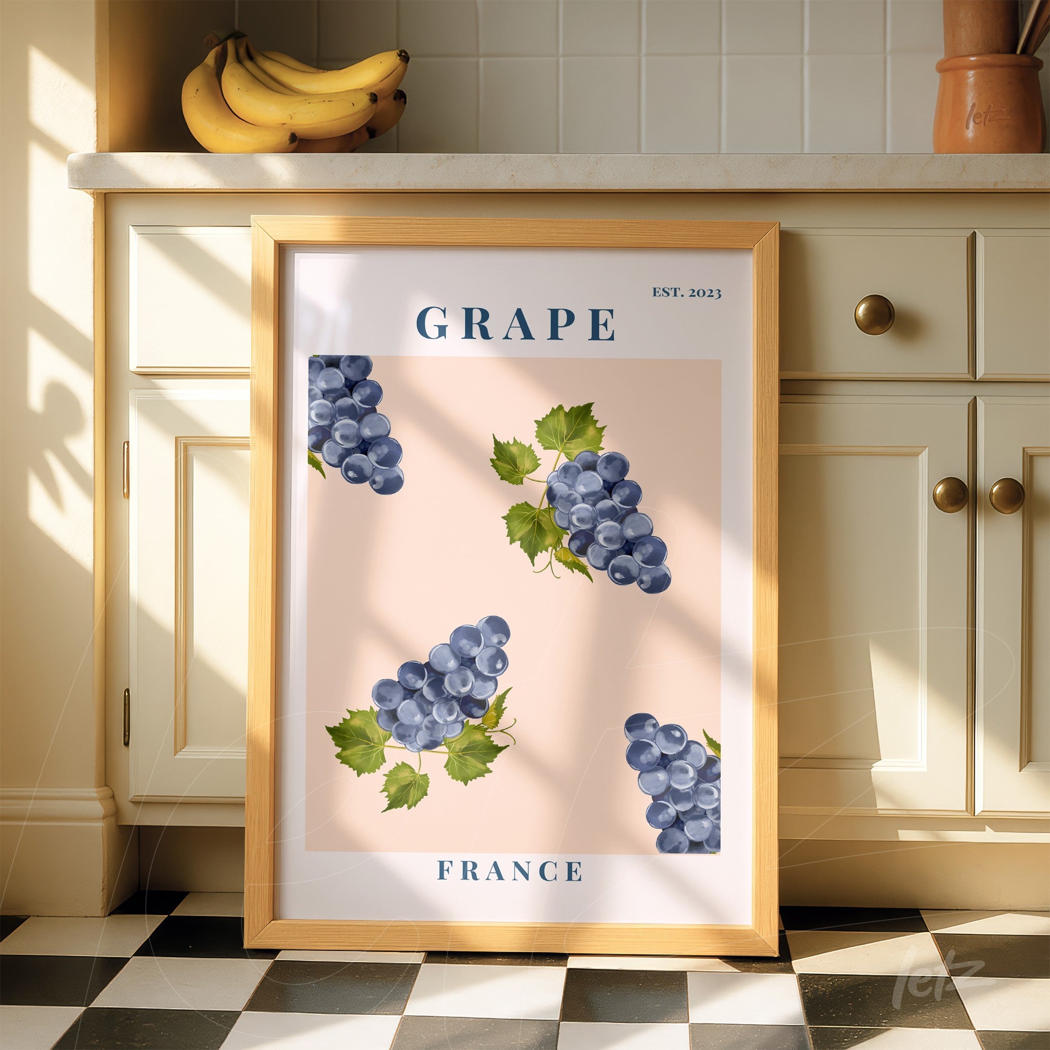 framed illustration of grapes on light pink background with light wood frame