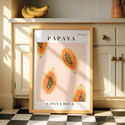 framed artwork featuring papayas on a pink background with light wood frame and text 'PAPAYA' and 'COSTA RICA'