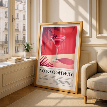 framed wall art featuring a stylized vodka cranberry cocktail with light wood frame, displayed in a bright room with window