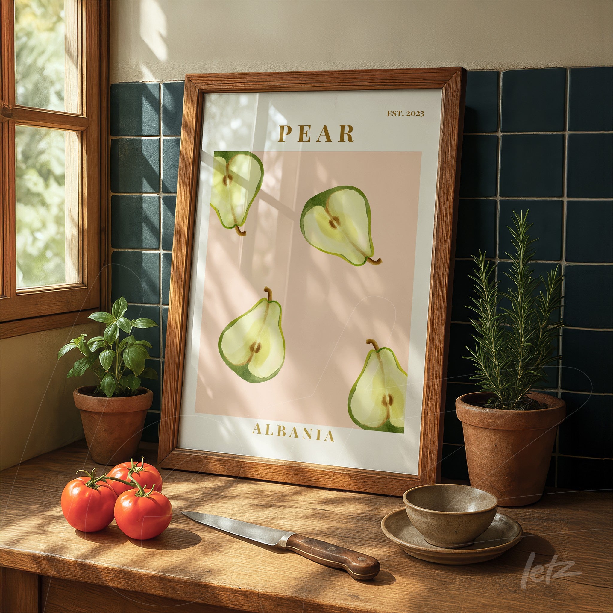 framed art featuring illustrations of pears on a pink background displayed on a wooden table with red tomatoes and herb pots