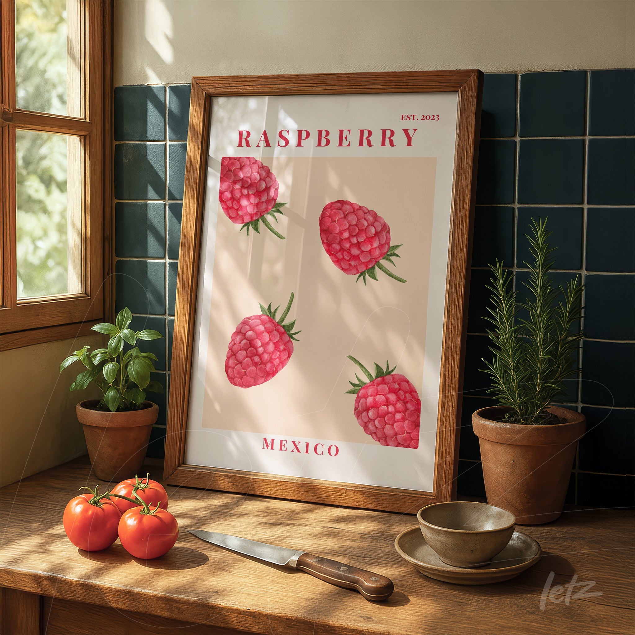 framed wall art featuring raspberries illustration with light wood frame on wooden table alongside vegetables
