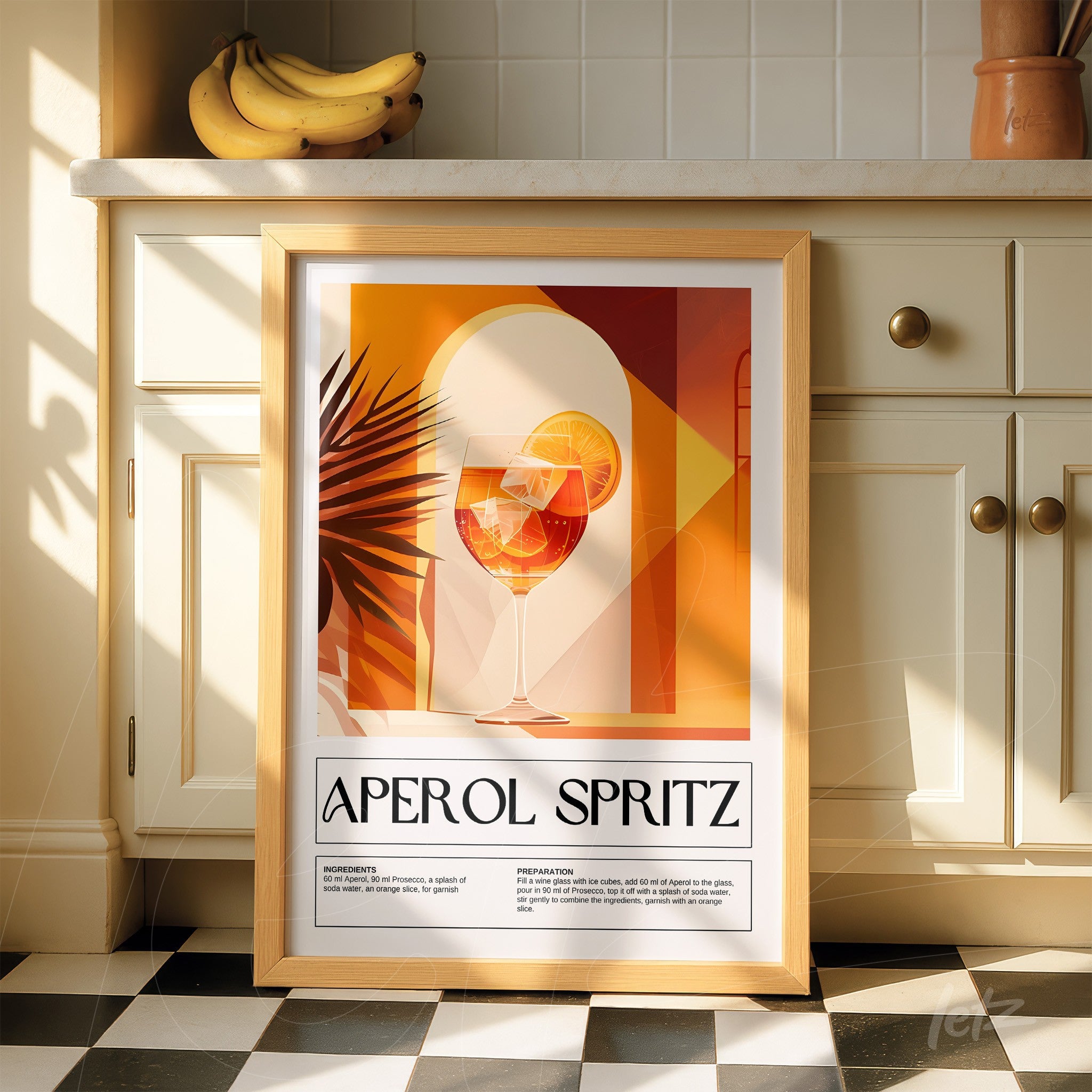 framed artwork of aperol spritz cocktail in light wood frame displayed in a sunlit kitchen