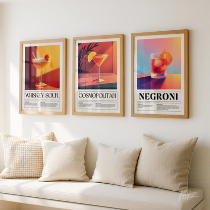 composition of three framed wall art prints of cocktails in golden frame with descriptive text, displayed on light wall