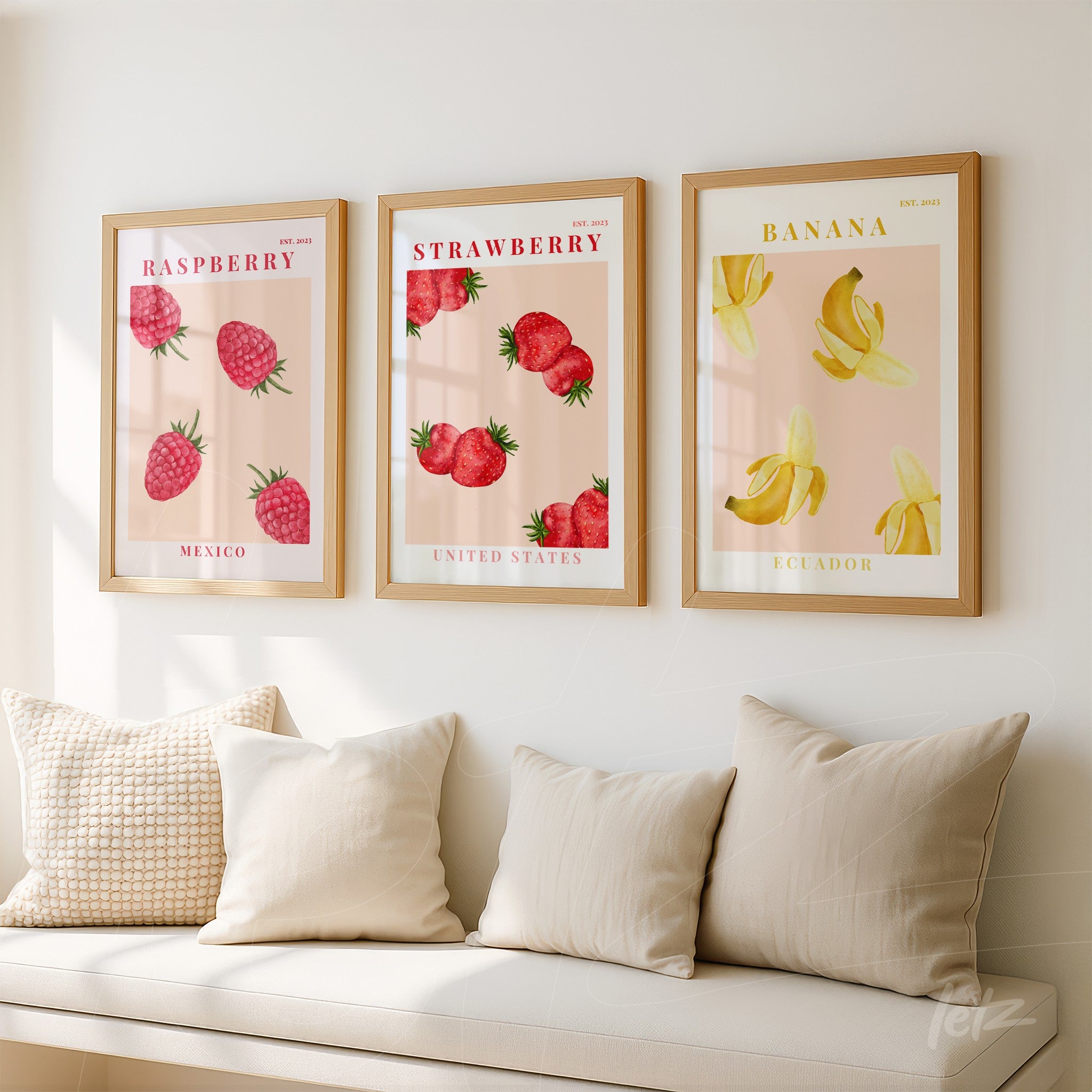 composition of framed wall art featuring fruits in light wood frames, including illustrations of raspberries, strawberries, and bananas on pink background