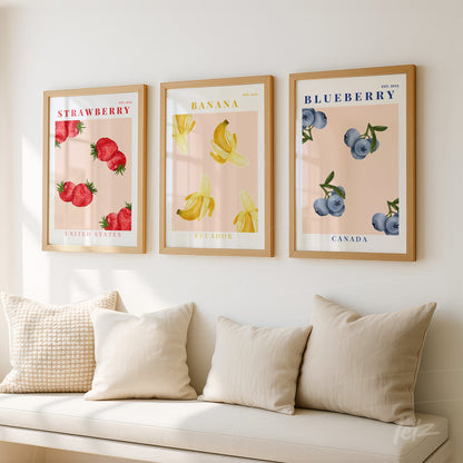 collection of three framed artworks featuring illustrations of strawberries, bananas, and blueberries on a soft background