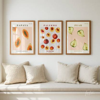 composition of three framed wall art pieces featuring tropical fruit illustrations with light wood frame on white wall