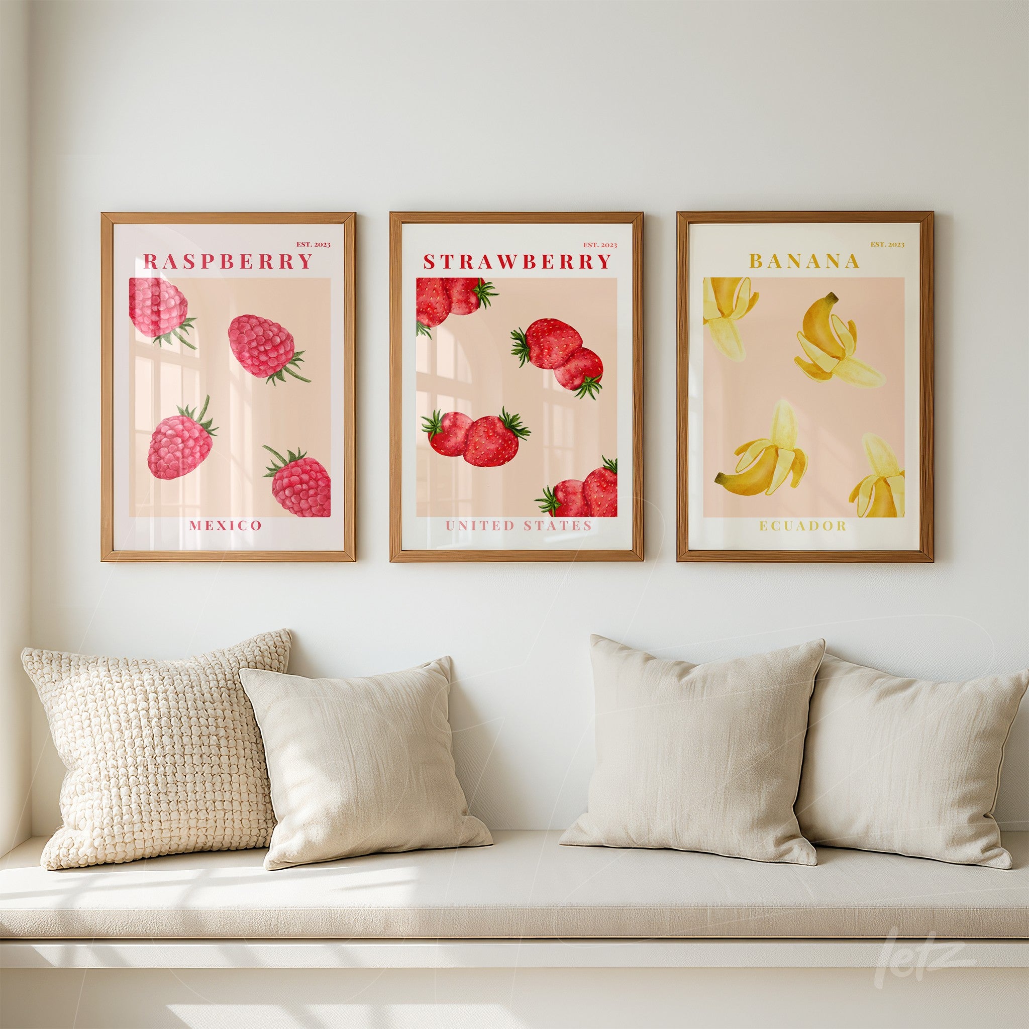 set of three framed wall art pieces featuring fruit illustrations: raspberry with Mexico flag, strawberry with United States flag, and banana with Ecuador flag in light wood frame against a neutral wall
