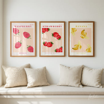 set of three framed wall art pieces featuring fruit illustrations: raspberry with Mexico flag, strawberry with United States flag, and banana with Ecuador flag in light wood frame against a neutral wall