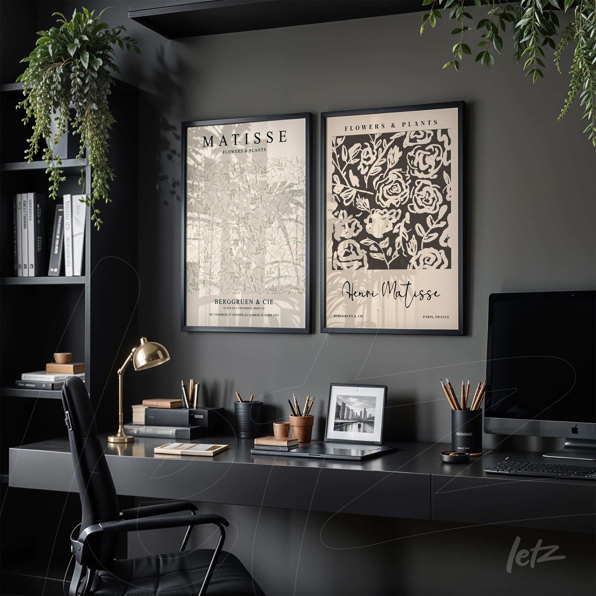 series of framed wall art featuring botanical illustrations in black frame displayed on dark wall with workspace elements