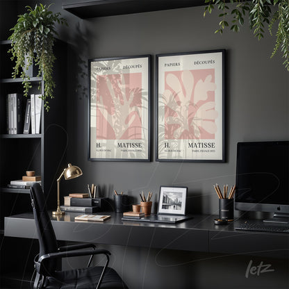 composition of two framed artworks featuring minimalist Matisse designs with black frames displayed on an office desk with plants