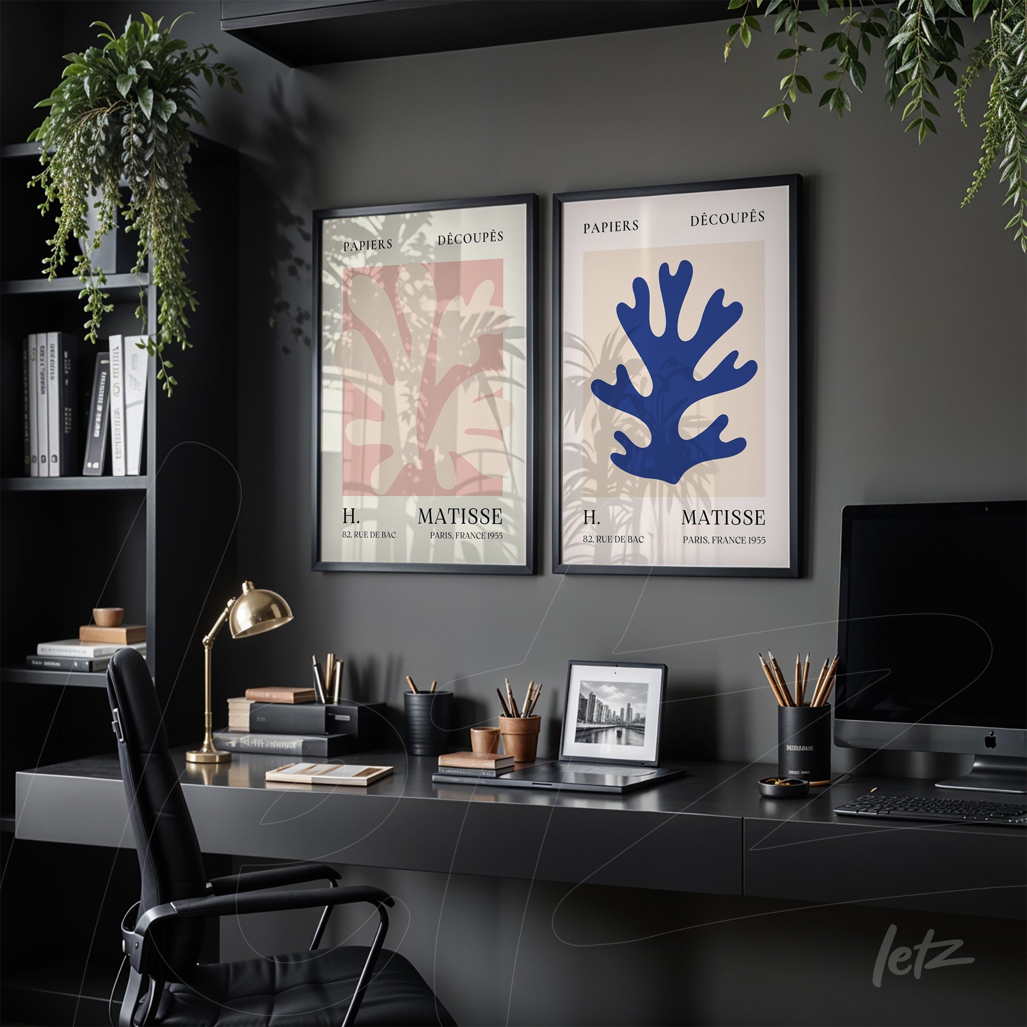 composition with two framed wall art pieces featuring matisse paper cut-out designs, set in a dark office space with a black desk and hanging plants