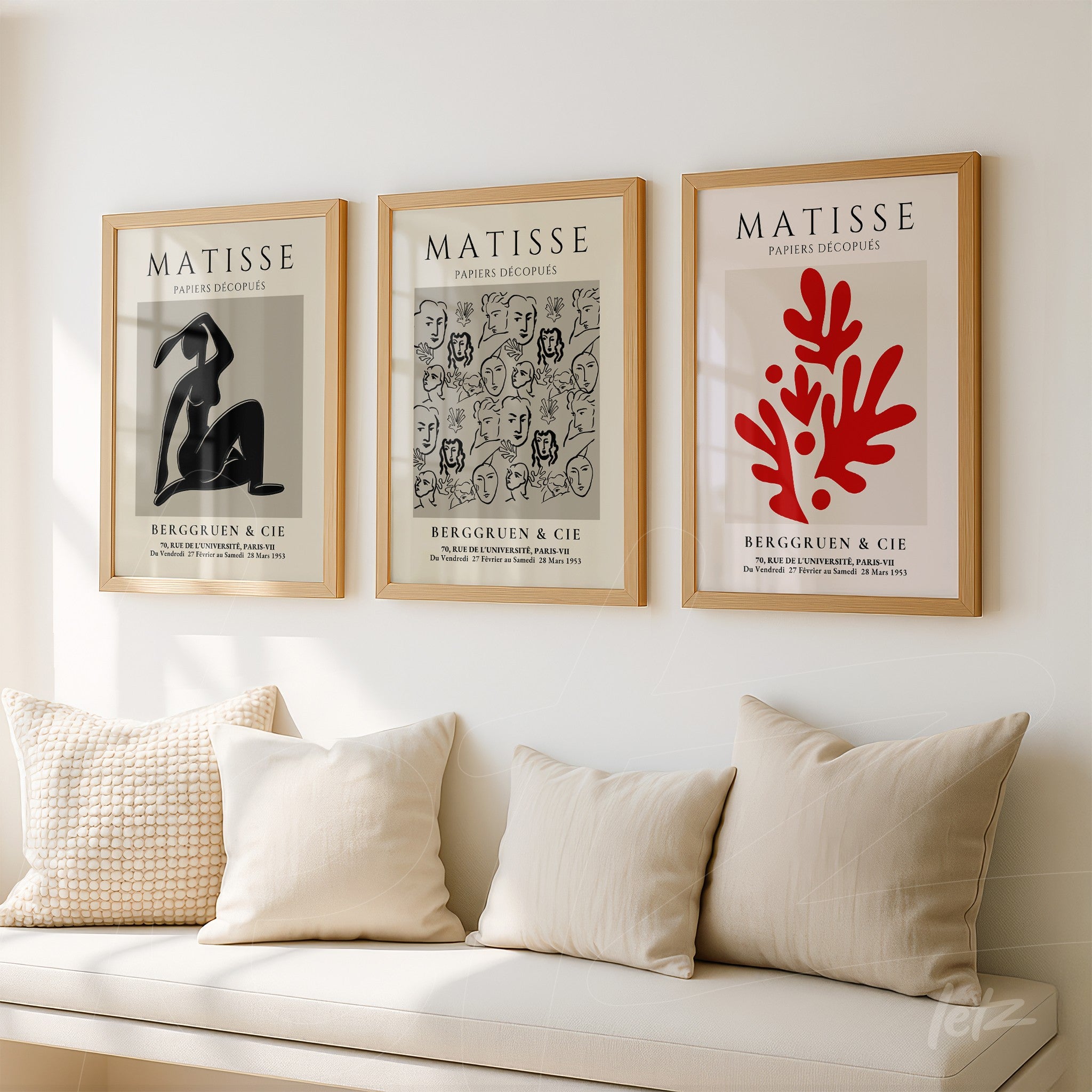 composition of three decorative frames featuring henri matisse illustrations in light wood frames displayed on a white wall above a sofa with light-colored cushions
