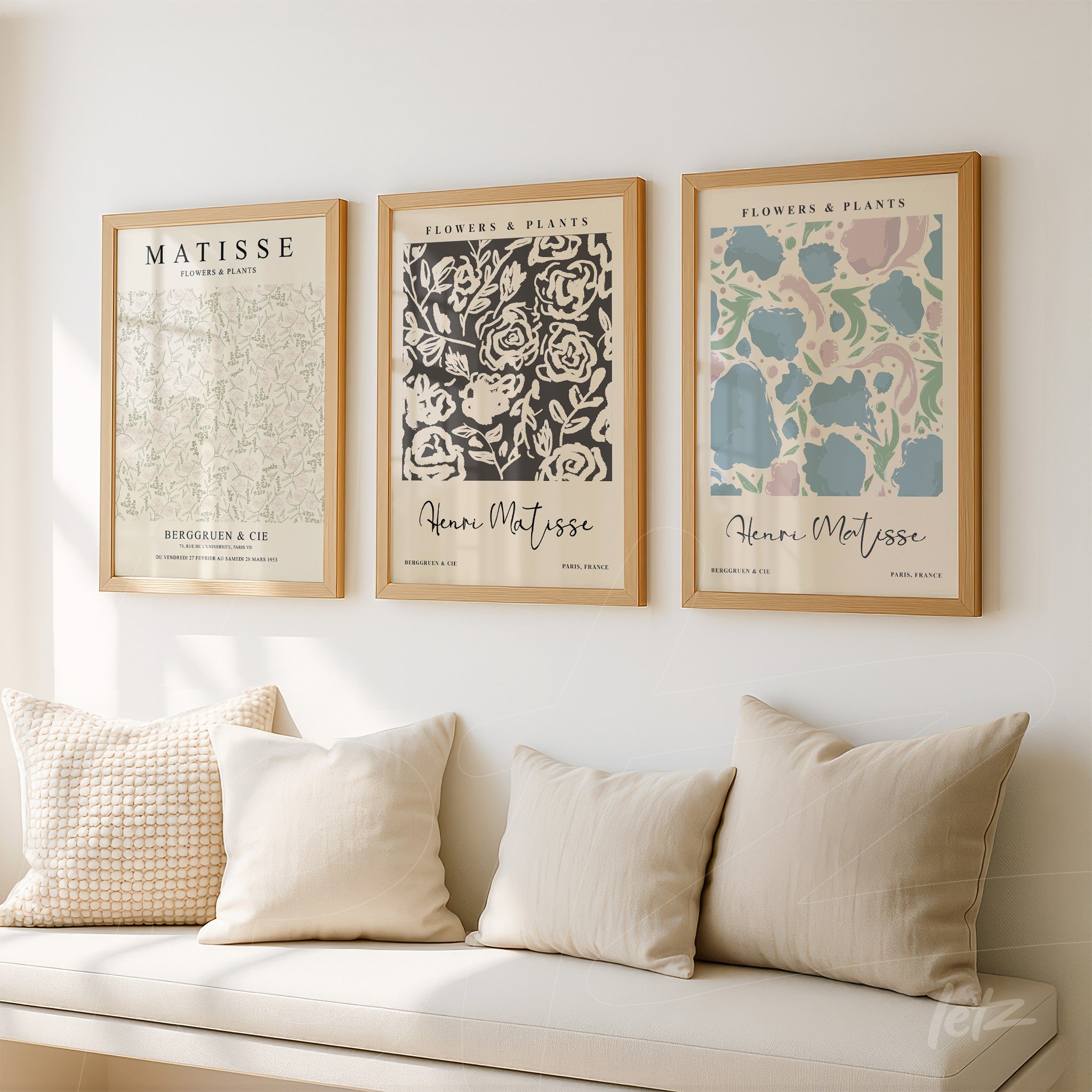 set of wall art prints featuring floral patterns in light wooden frames above a sofa with neutral cushions