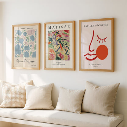 composition of three decorative framed artworks in light wood frames featuring designs inspired by Henri Matisse, showcasing flowers, plants, and abstract shapes
