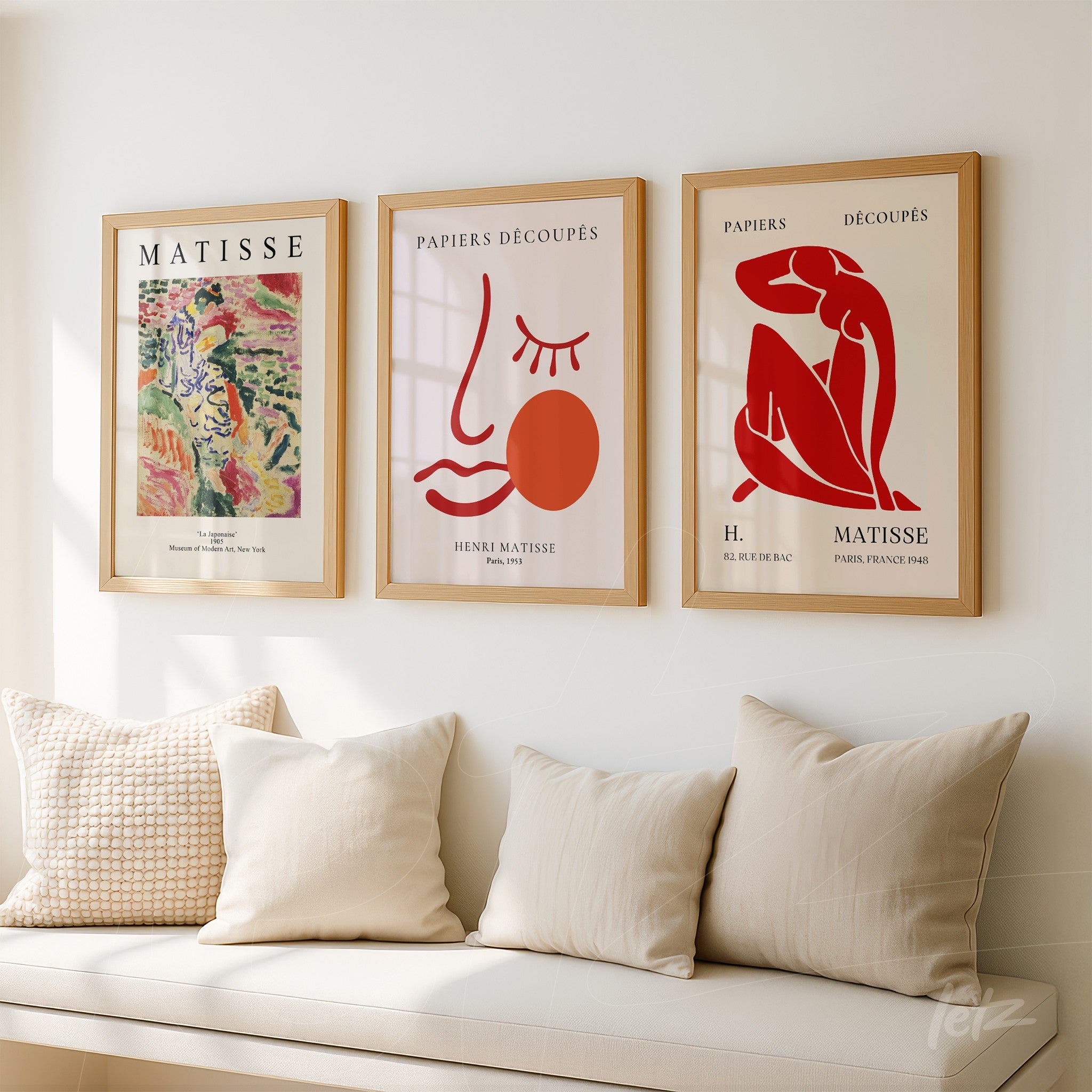 composition of three framed wall art pieces by Henri Matisse in light wood frames on a white wall