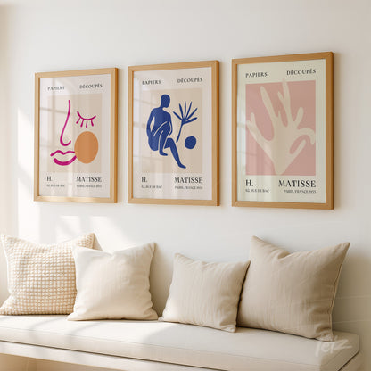 composition of three framed wall arts in light wood with abstract designs in soft colors and stylized figures