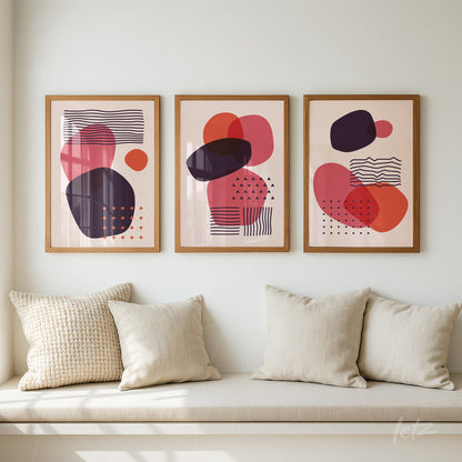 set of three framed abstract art prints in pink and purple displayed on a white wall