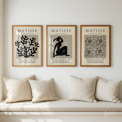 series of framed matisse art pieces in light wood frames displayed above a cream pillow sofa