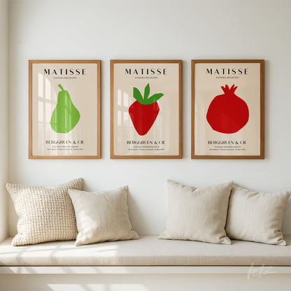 composition of three framed wall artworks featuring minimalist illustrations of colorful fruits in light wood frames against a light wall