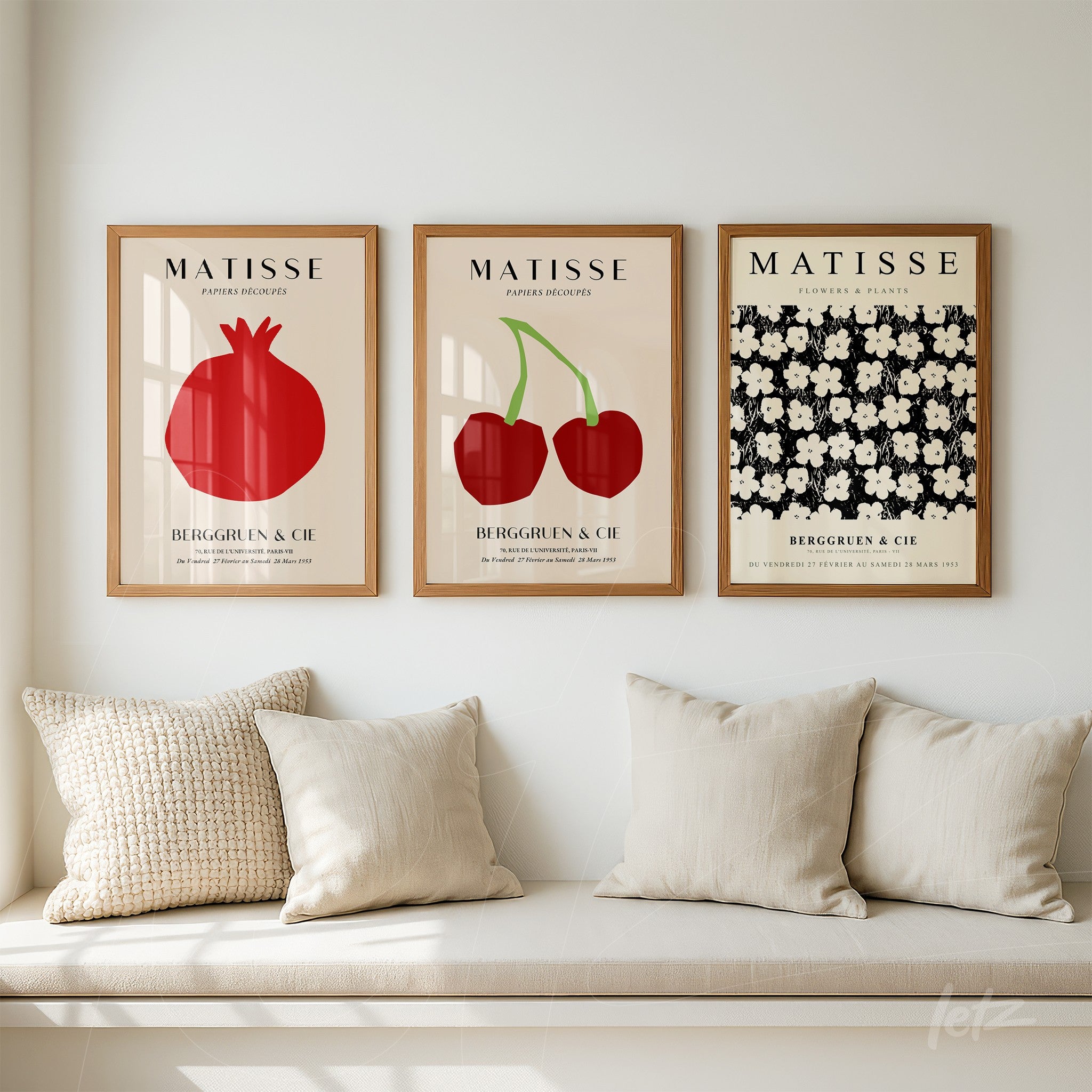 composition of three framed artworks in light wood featuring botanical illustrations of pomegranate, cherries, and white flowers on dark background