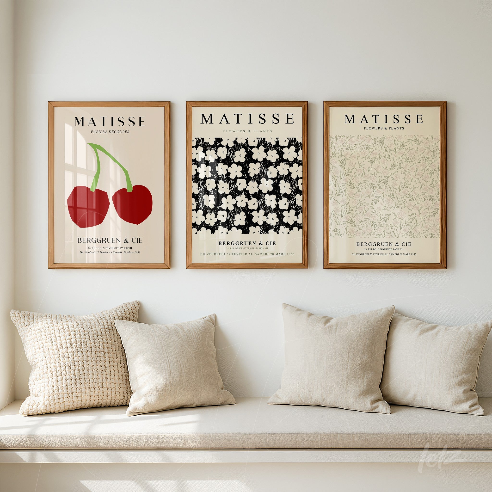 collection of three framed artworks inspired by Matisse, featuring red cherries, white flowers on black background, and light green floral pattern in light wood frame