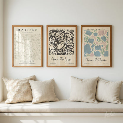 series of decorative wall art featuring flower illustrations in light wooden frames on a white wall