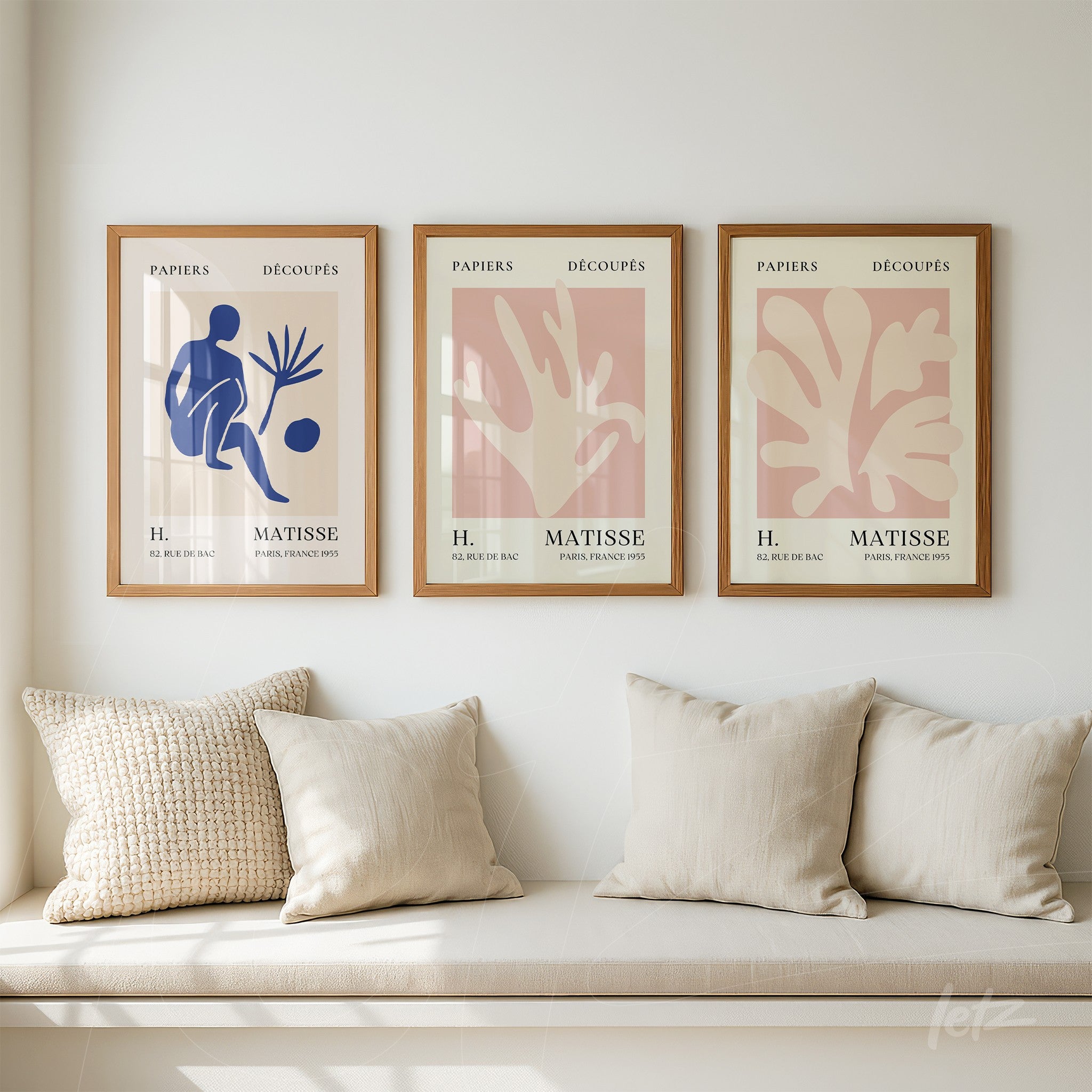 collection of three framed artworks in light wood showcasing modern art with organic shapes and figures in shades of blue and pink