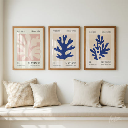 set of three modern framed wall art pieces featuring leaf designs in pink and blue colors displayed on a neutral wall