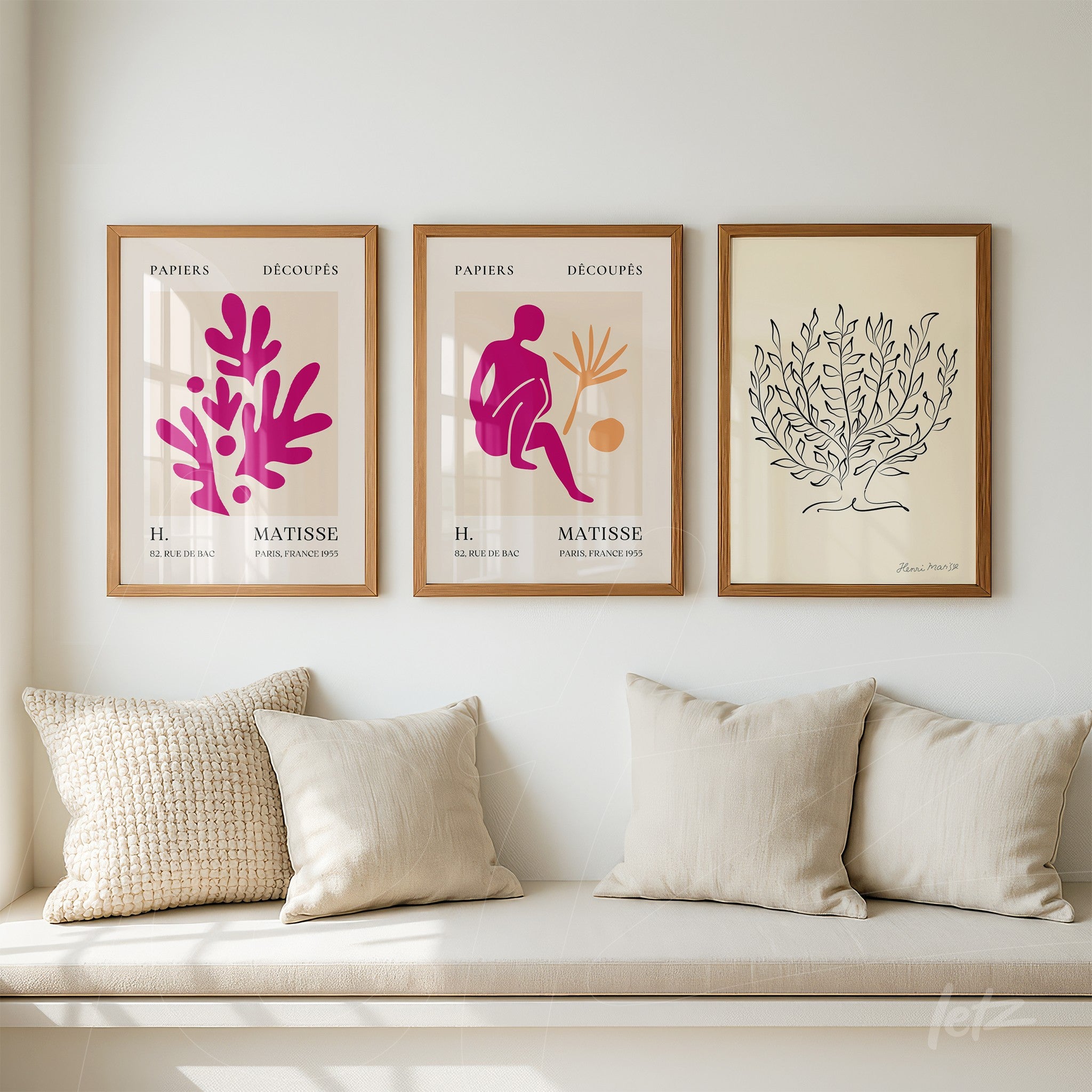 framed collection of three decorative artworks featuring abstract designs in pink and purple inspired by Matisse and a black leaf illustration on a light wood frame