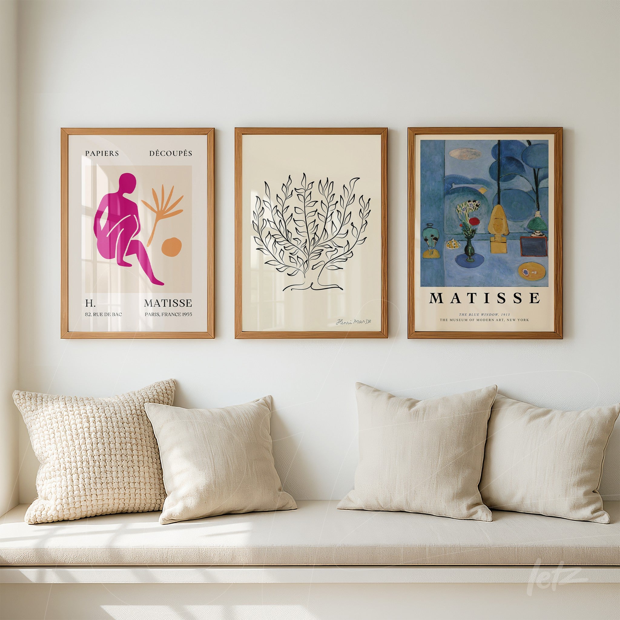 set of framed modern art prints by Henri Matisse displayed on a white wall above a cozy sofa
