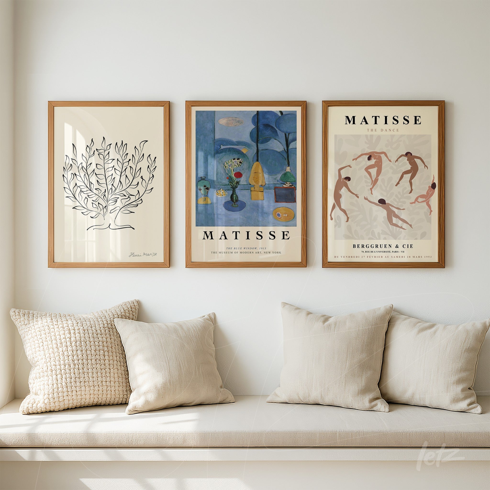 composition of three framed artworks in light wood, featuring a line drawing of a plant, colorful Matisse art with abstract elements, and vintage style dancers, displayed on a neutral wall