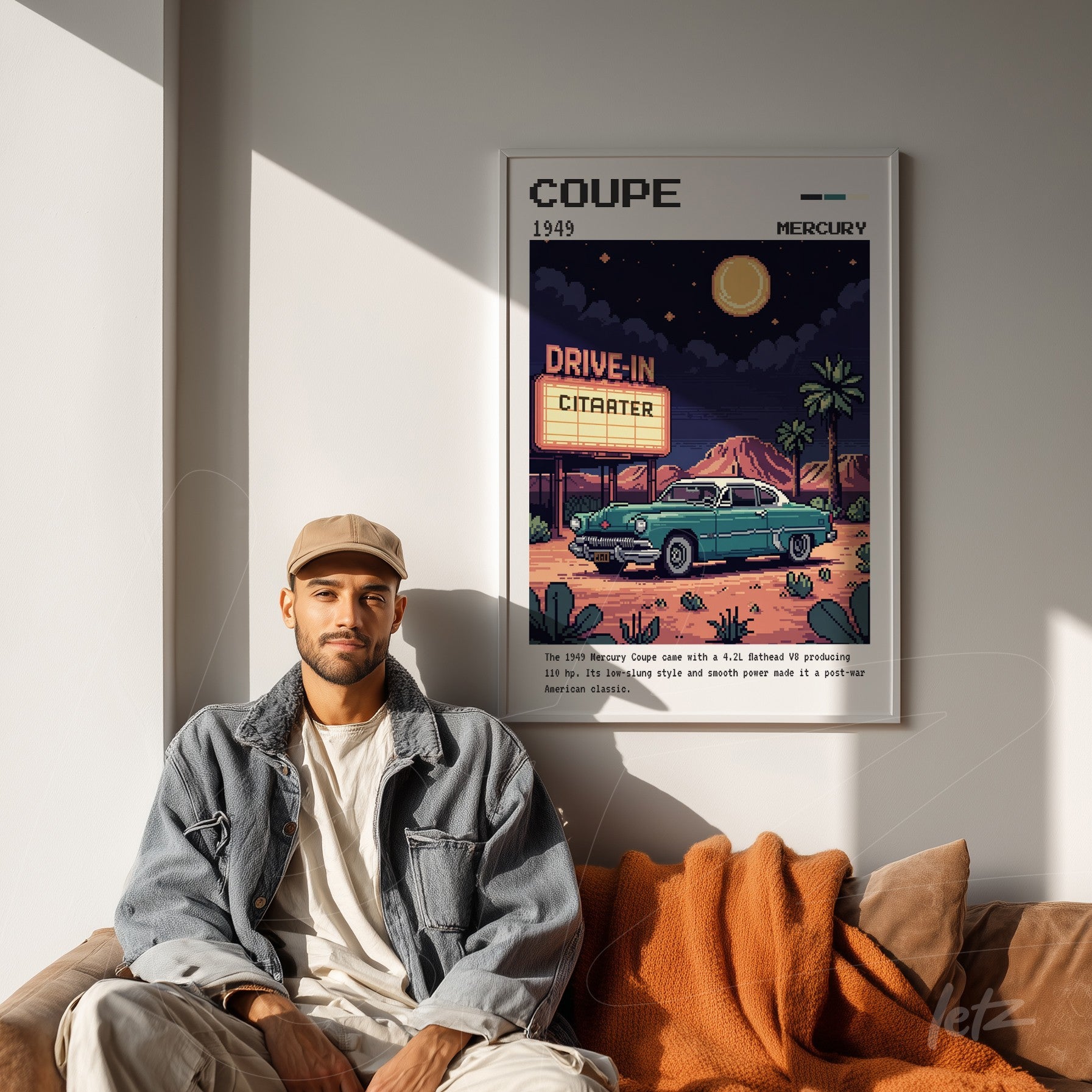 retro style framed art featuring a 1949 Mercury car in a drive-in cinema scene with white frame displayed on a light wall next to a man sitting on a sofa