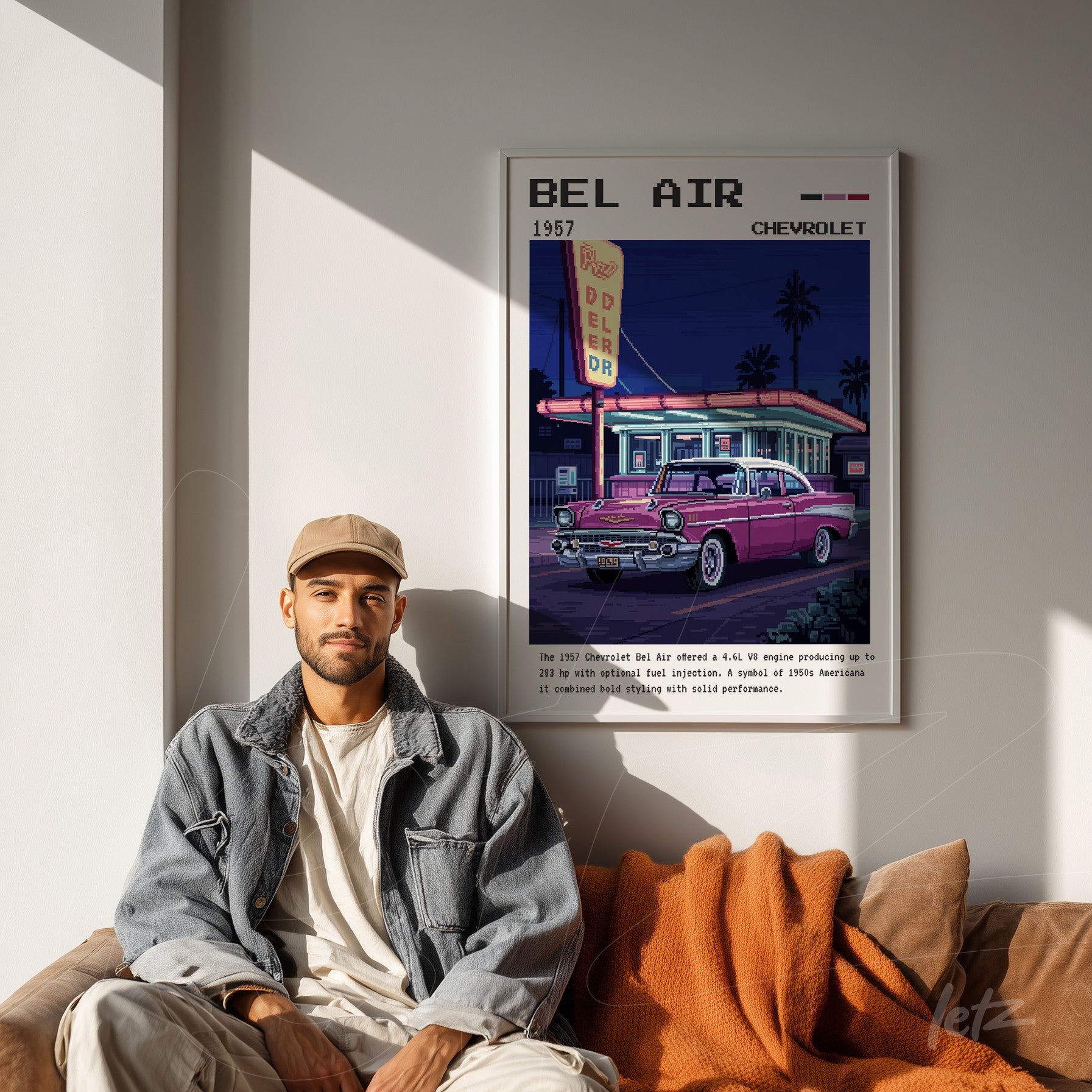 framed vintage art of 1957 Chevrolet Bel Air at night, displayed on light wall next to a smiling man with an orange throw blanket