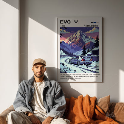 framed pixel art of Mitsubishi EVO V car in mountainous landscape displayed on wall above couch with orange throw blanket