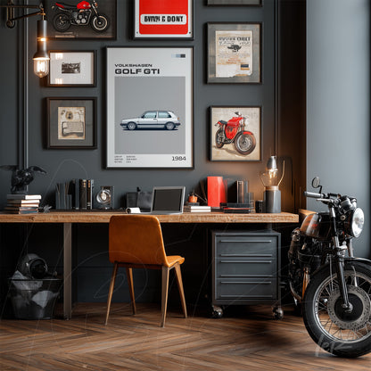 display of vintage wall art on dark blue wall with light wood desk and leather chair, featuring a poster of 1984 Volkswagen Golf GTI