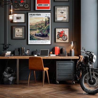 series of framed vintage car art prints in dark frames displayed on gray wall with a wooden desk and a motorcycle nearby