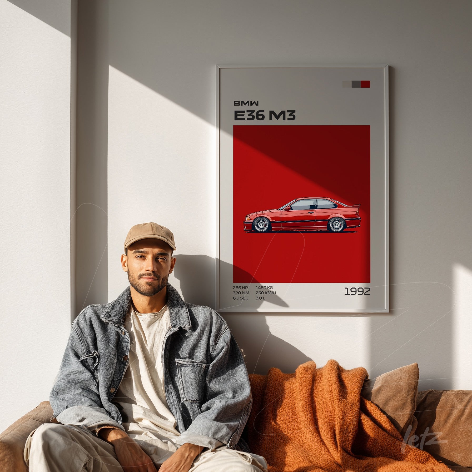 framed wall art featuring a bmw e36 m3 illustration on a vibrant red background displayed next to a man sitting on a sofa