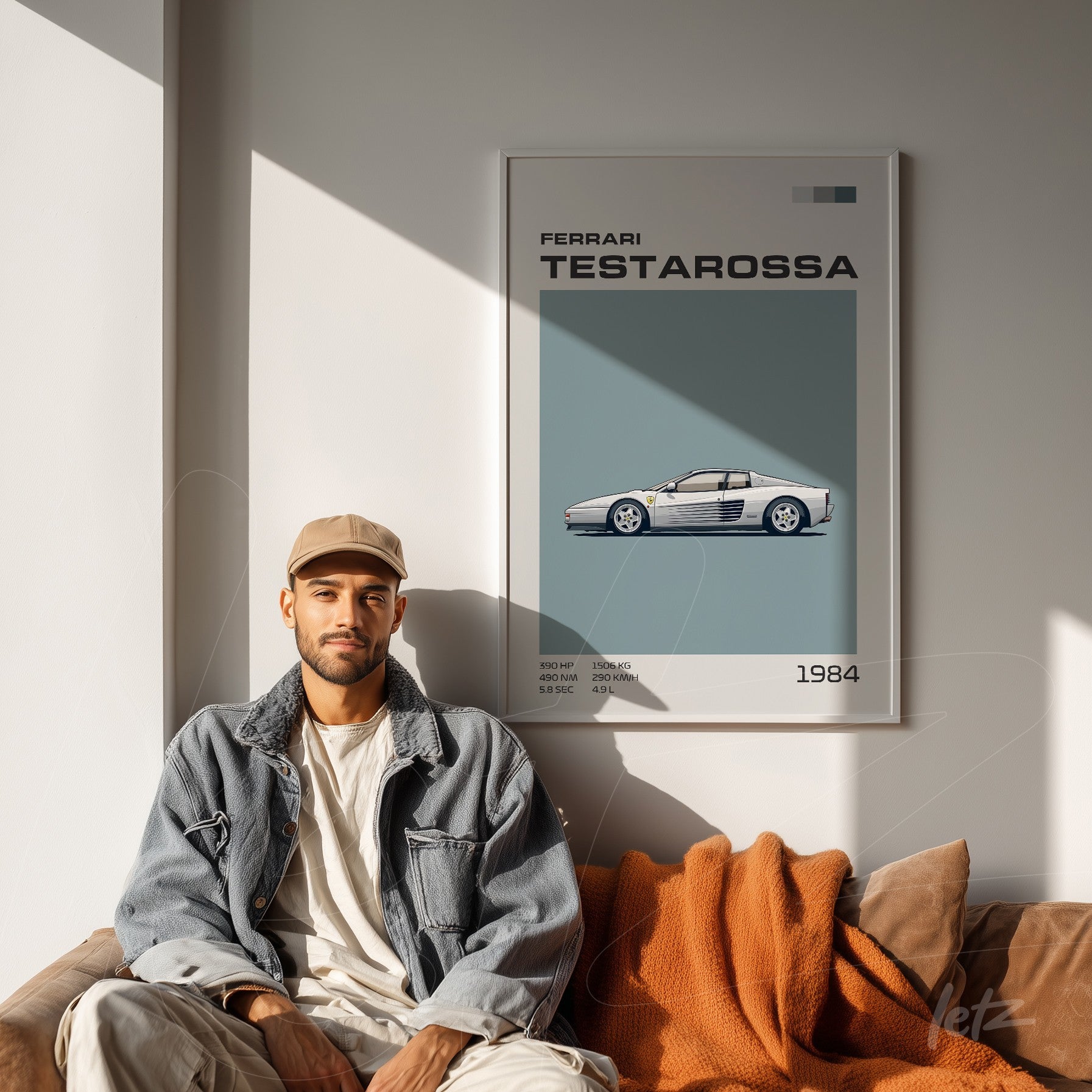 framed wall art featuring a Ferrari Testarossa illustration displayed on a light wall with a man sitting beside it