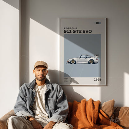 framed wall art featuring the Porsche 911 GT2 EVO against a neutral wall with a man sitting on a leather sofa