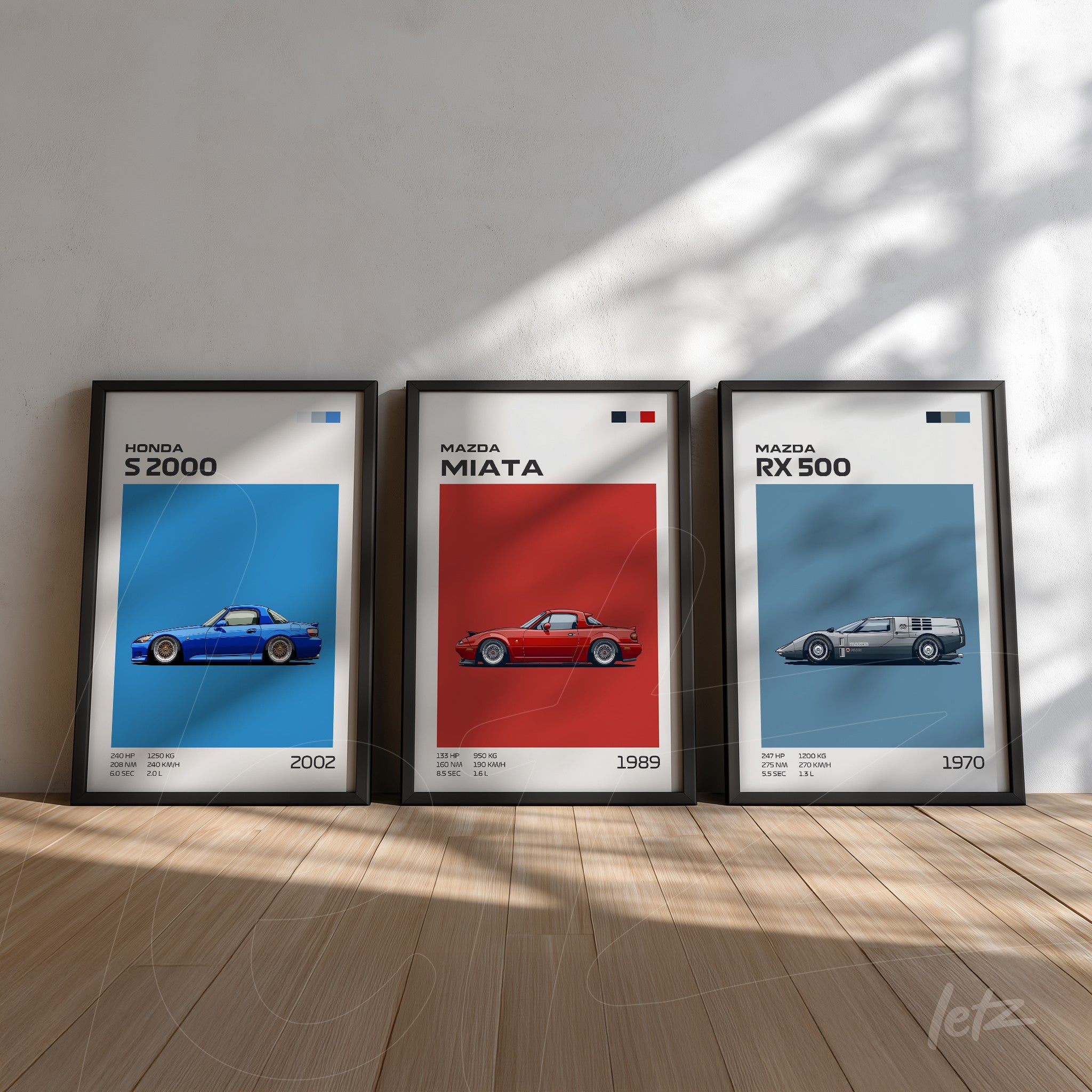 collection of three framed art pieces featuring car illustrations, including blue honda s2000, red mazda miata, and silver mazda rx 500, displayed on wooden floor