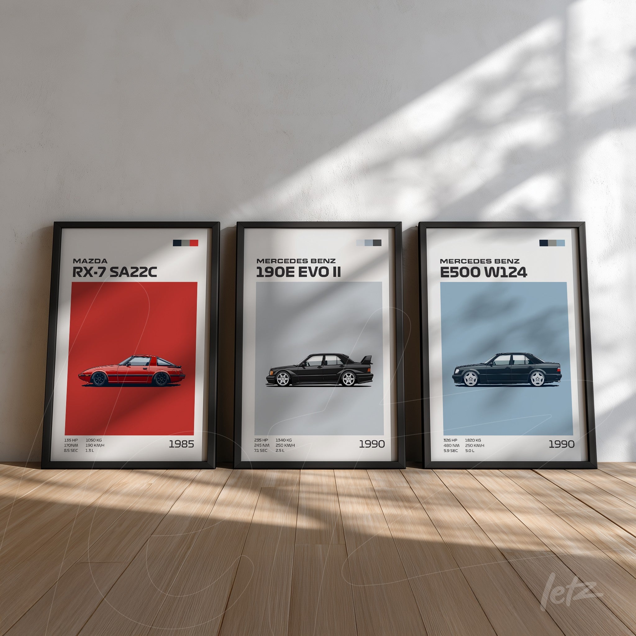 collection of three framed wall art pieces featuring classic cars, showcasing the 1985 Mazda RX-7 SA22C, the 1990 Mercedes-Benz 190E EVO II, and the 1990 Mercedes-Benz E500 W124 against a light background on wooden floor