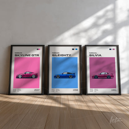 set of framed wall art featuring Nissan car illustrations in black frames, showcasing the Skyline GTR, Sil80, and Silvia on pink and blue backgrounds