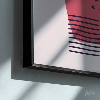 modern decorative frame with geometric shapes in shades of pink and burgundy featuring a slim black frame