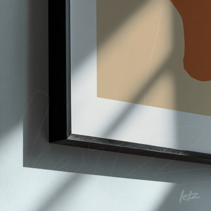 detail of minimalist art in earthy tones with thin black frame, natural light casting shadows